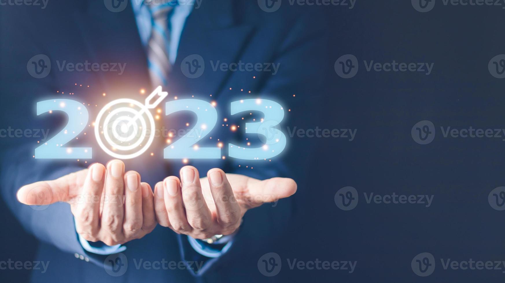 business target and goal on New year 2023 concept, hand holding 2023 virtual screen. new years business. new ideas coming up in the future. photo