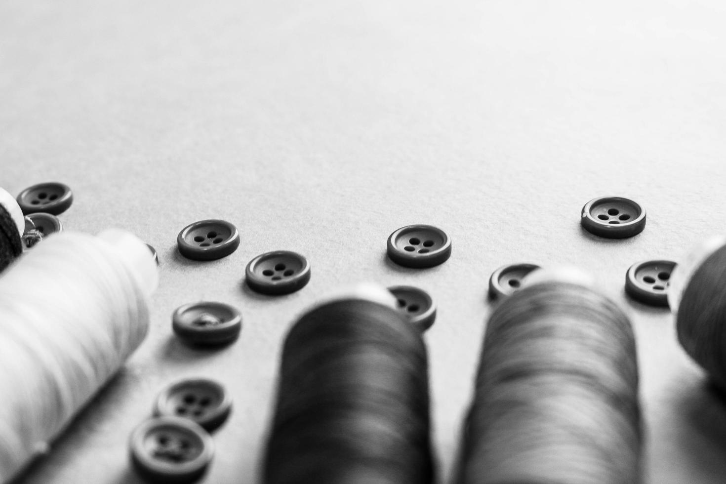 A beautiful black and white texture with many round buttons for sewing, needlework and coils of yarn. Copy space. Flat lay. the background photo