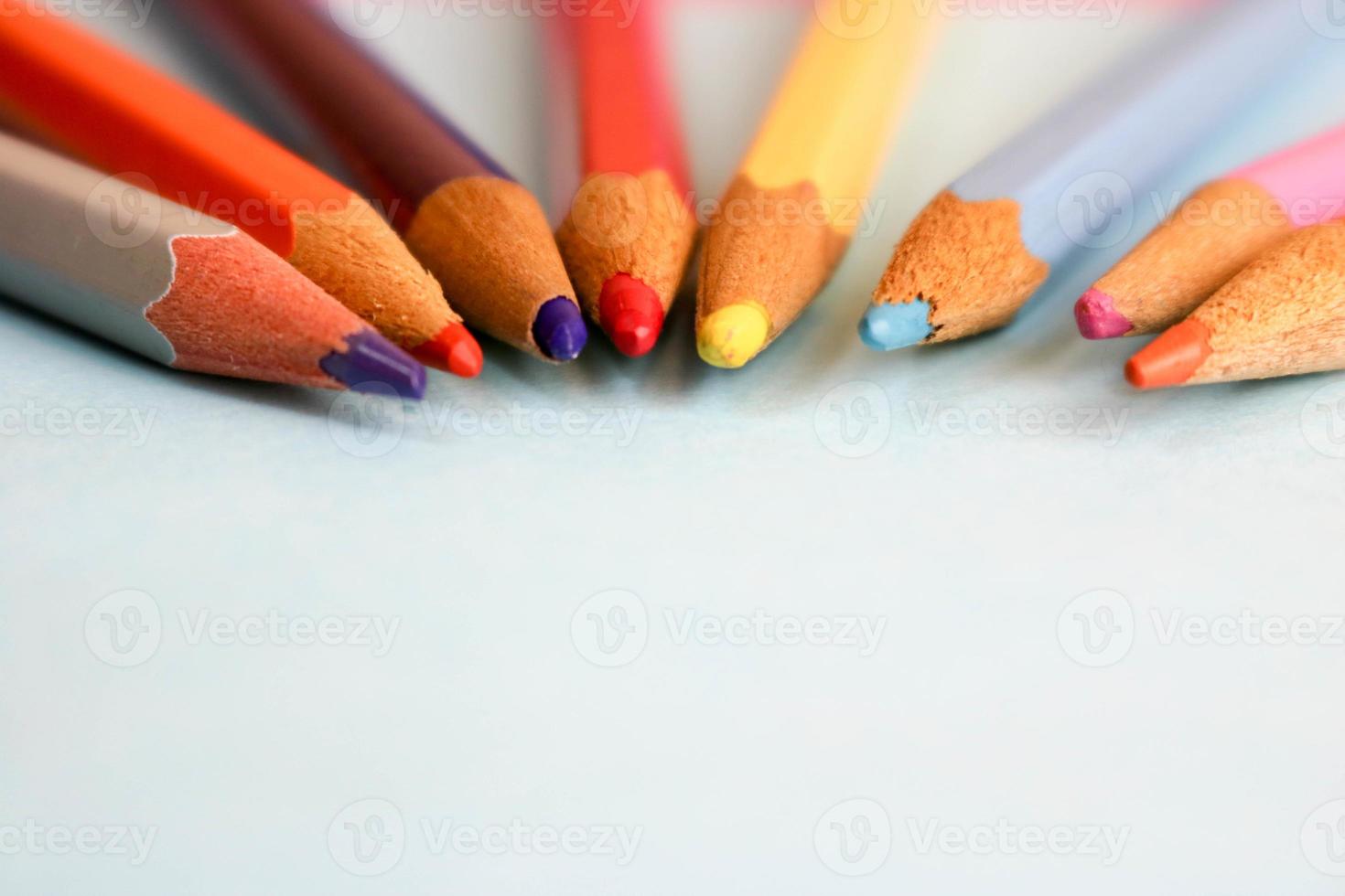 Beautiful bright colored wooden colored sharpening pencils for drawing. Flat lay and copy space on blue background photo