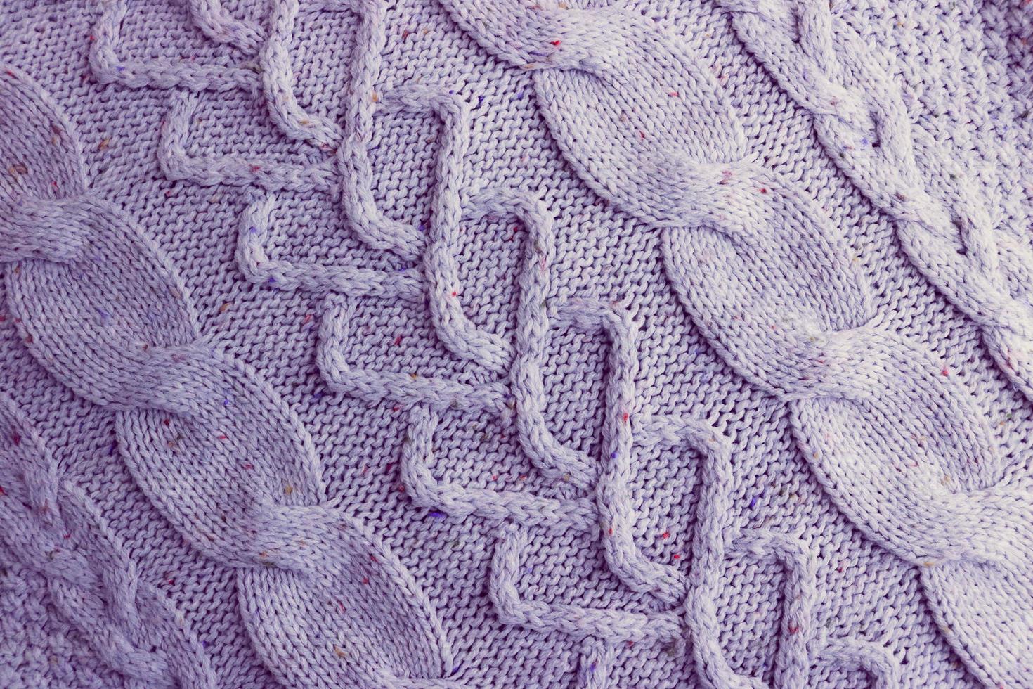 Beautiful texture of a soft warm natural sweater with a knitted pattern of threads. The background photo