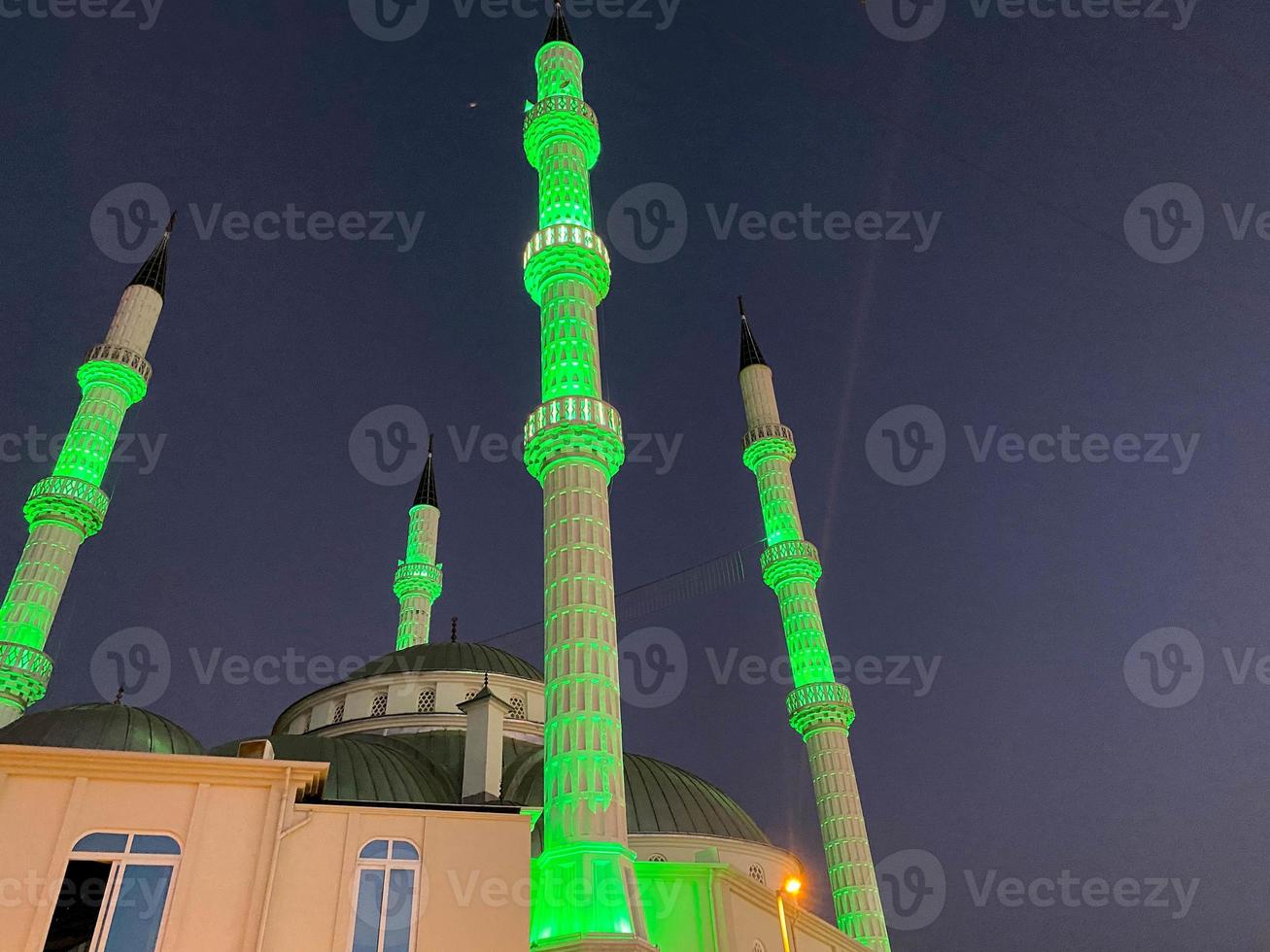 Large beautiful high muslim mosque islamic temple for prayers to god allah with high religion towers in warm tropical eastern country southern resort at night photo