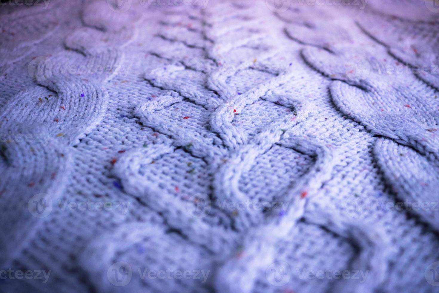 Beautiful texture of a soft warm natural sweater with a knitted pattern of threads. The background photo