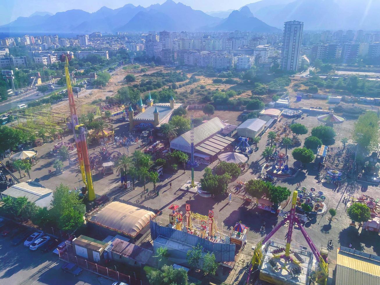 en la ciudad vista a las montañas y al mar. visita turística. casas, edificios, árboles tropicales, palmeras, rotondas, arbustos y caminos son visibles foto