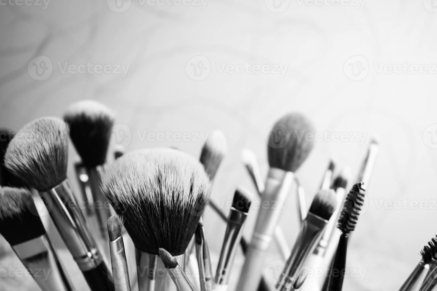 un conjunto de hermosos pinceles suaves en blanco y negro para maquillaje de siesta natural para orientación de belleza y aplicación de una base tonal en el stand foto