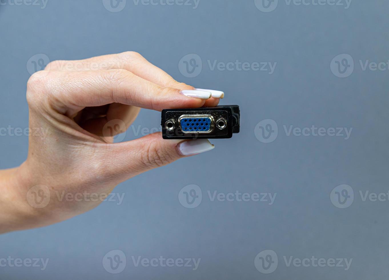 Hands holding various converter cables adapters for computers and smartphones photo