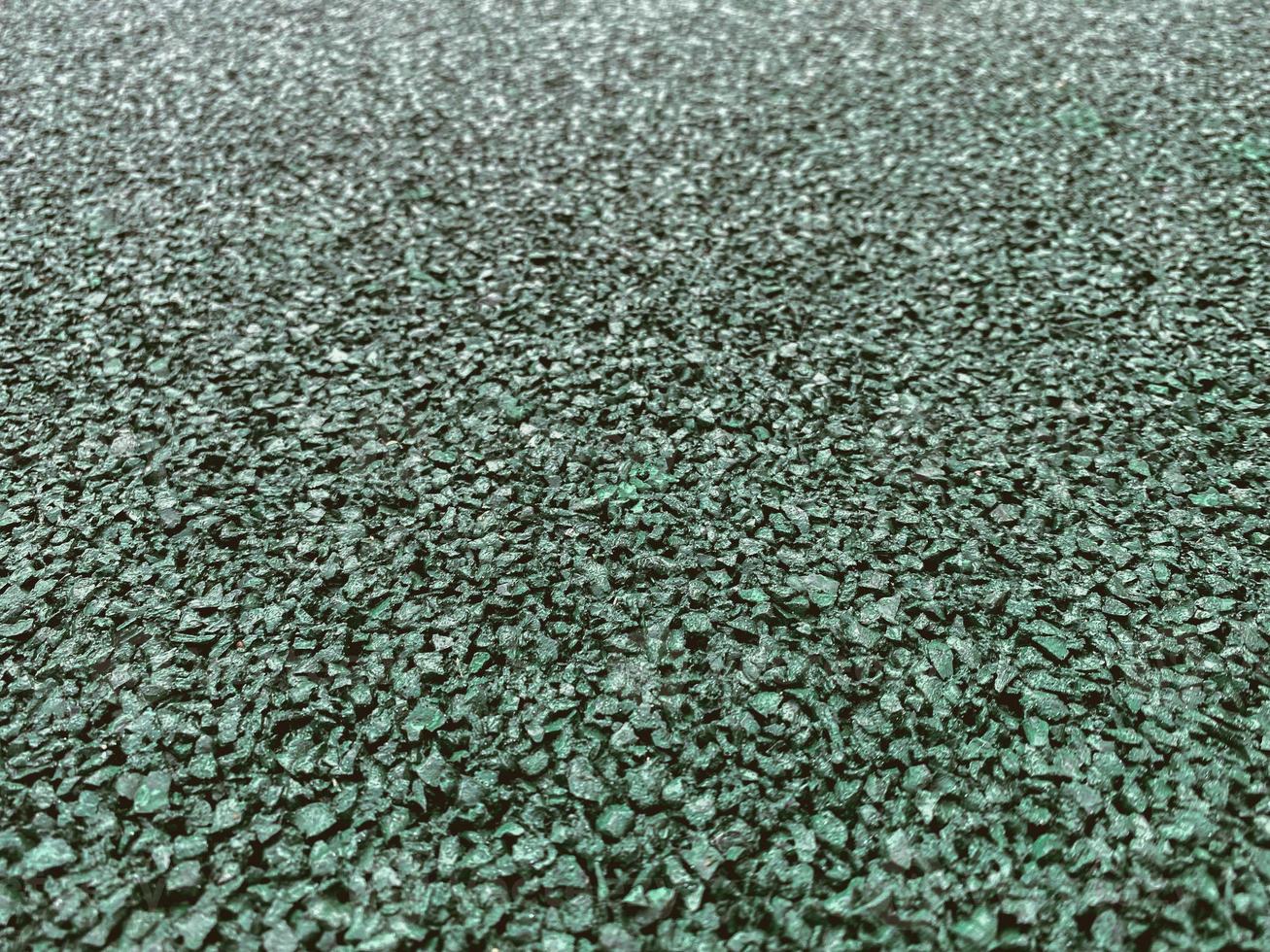 texture, background. coating for a sports field made of rubberized material in green, emerald color. anti-slip running surface photo