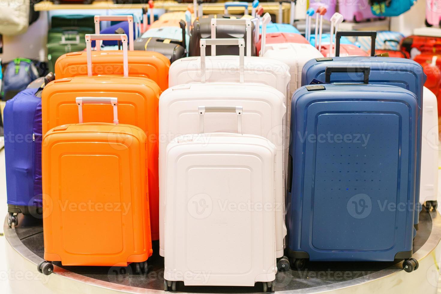 Blue and yellow and white suitcases or travel bag in a row on a shelf photo