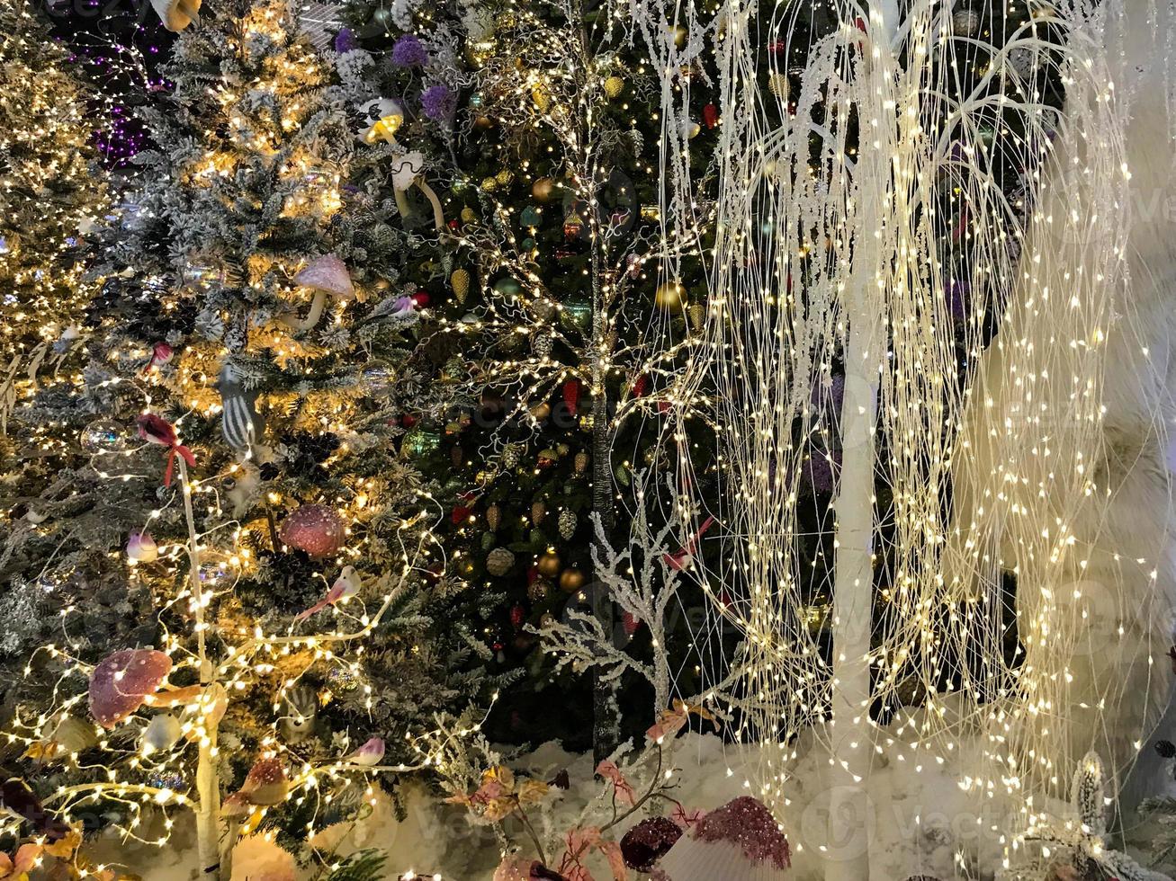 Festive green Christmas tree decorated with gold and red toys balls and bows with soft focus in evening and beautiful dark blurred defocused sparkling background with golden highlights, copy space photo