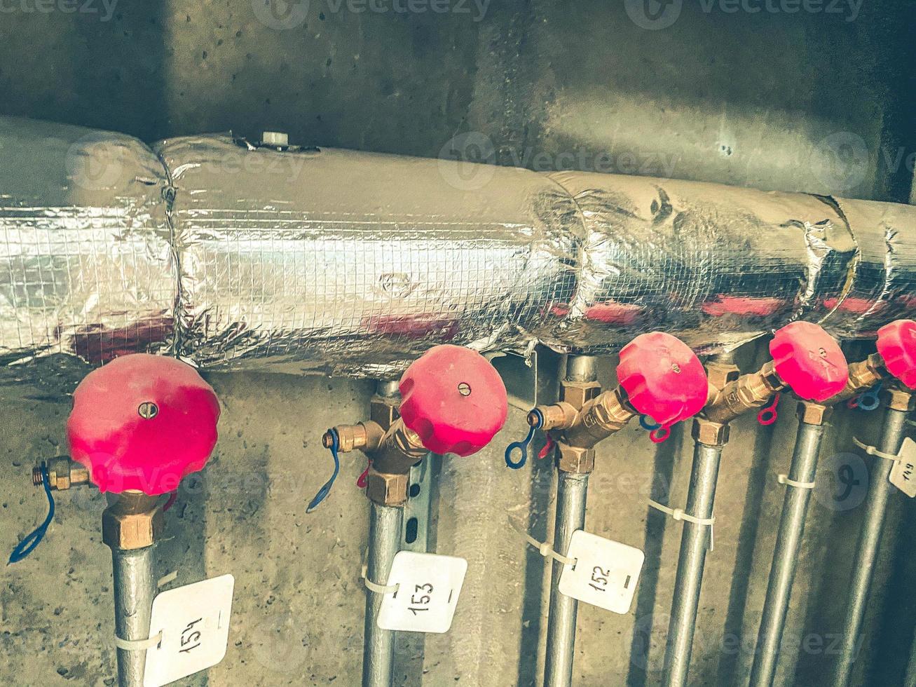 counters for the supply of energy resources to the apartment. on the meters, the valves cut off the water supply to the apartments. counters hang on a foil pipe photo
