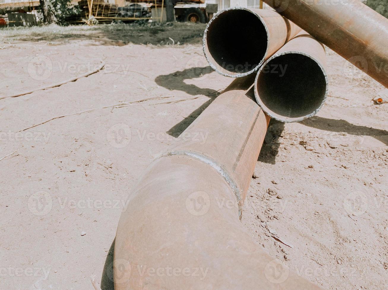 metal pipe lies on the ground. the metal pipe is soldered from the material. laying communications for residential buildings photo