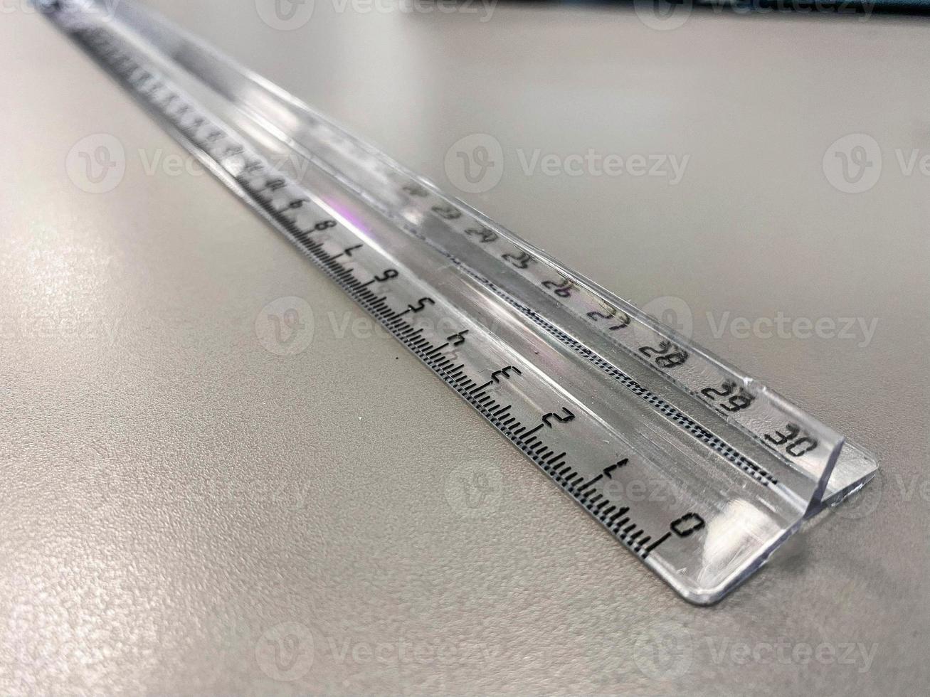 a transparent centimeter ruler lies on the table. supplies for mathematics and geometry. measuring centimeters in a workbook photo