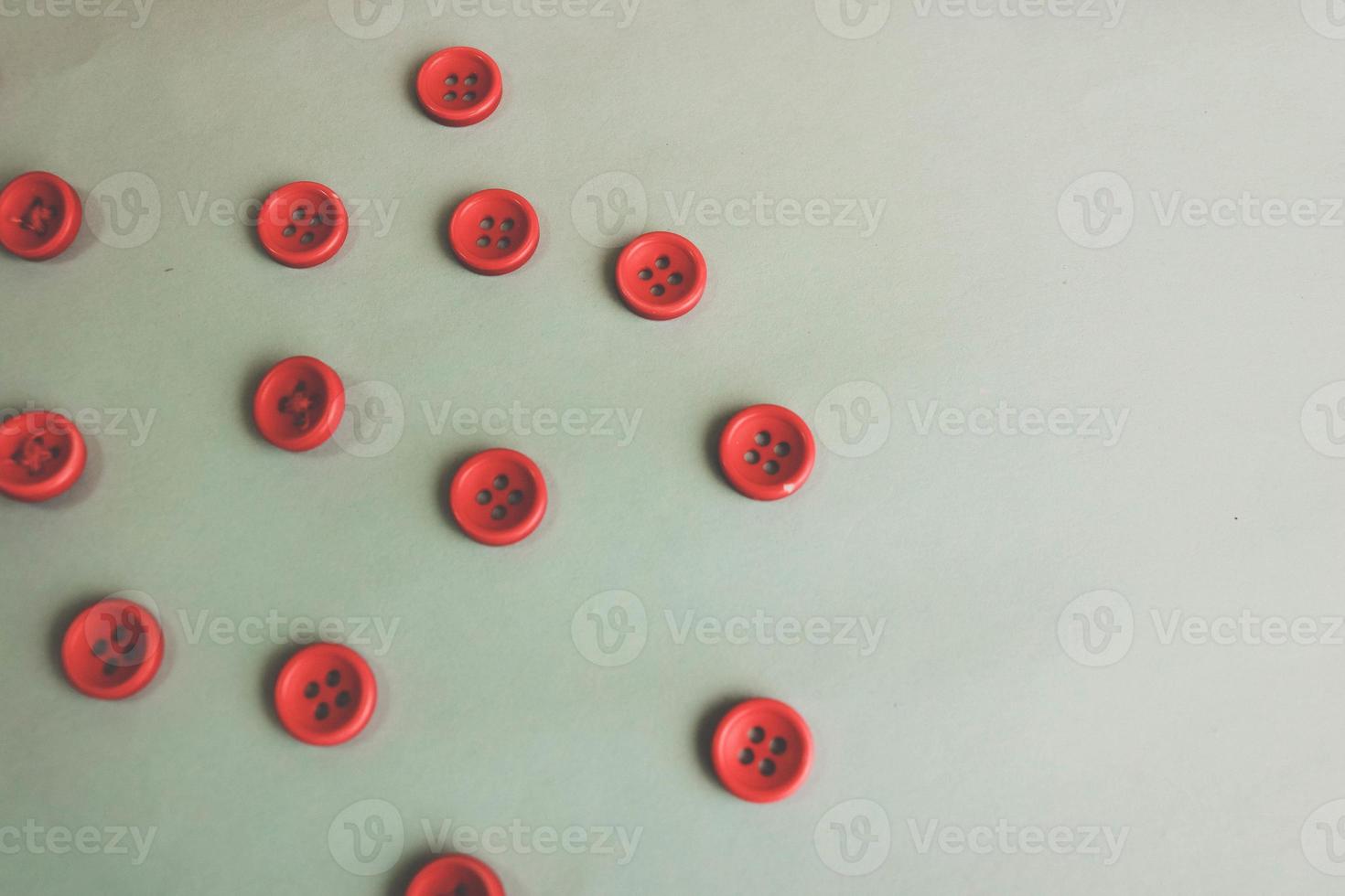 Beautiful texture with many round red buttons for sewing, needlework. Copy space. Flat lay. Blue background photo