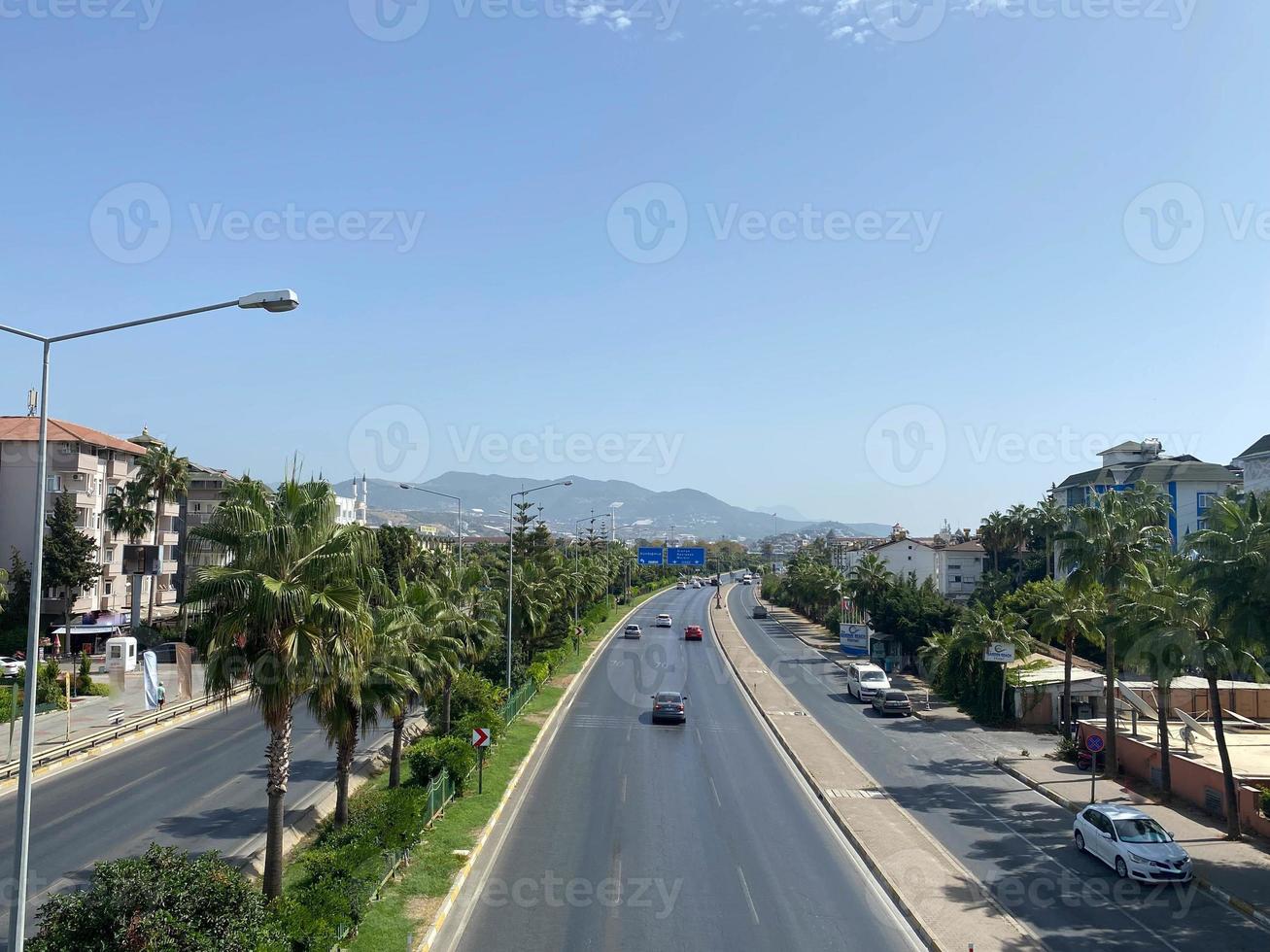 Large wide multi-lane highway road with palm trees on the sides in a warm tropical country southern resort photo