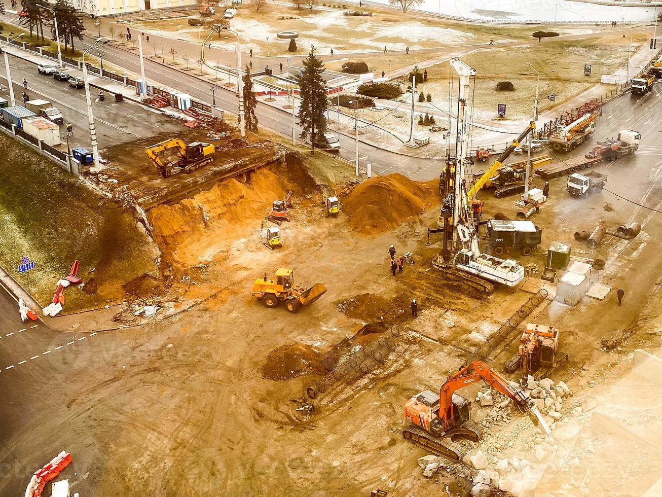 construction of a broken bridge on a busy road. construction equipment at the site erects an overpass from concrete structures. laying new asphalt photo