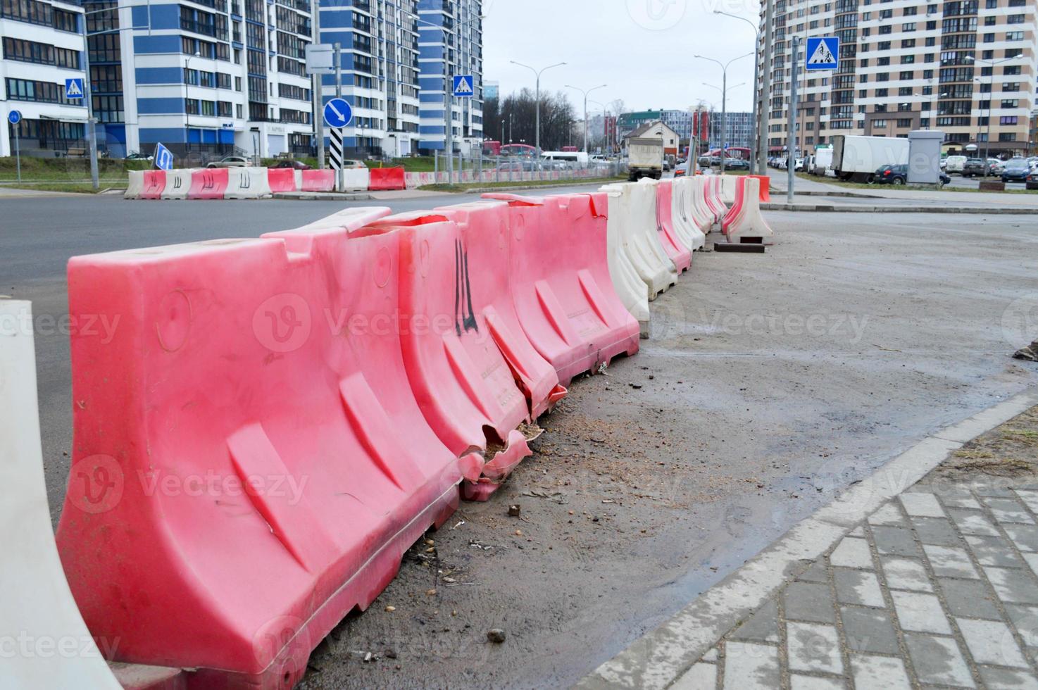 grandes bloques de plástico rojo y blanco llenos de agua para la seguridad vial durante la reparación de carreteras foto