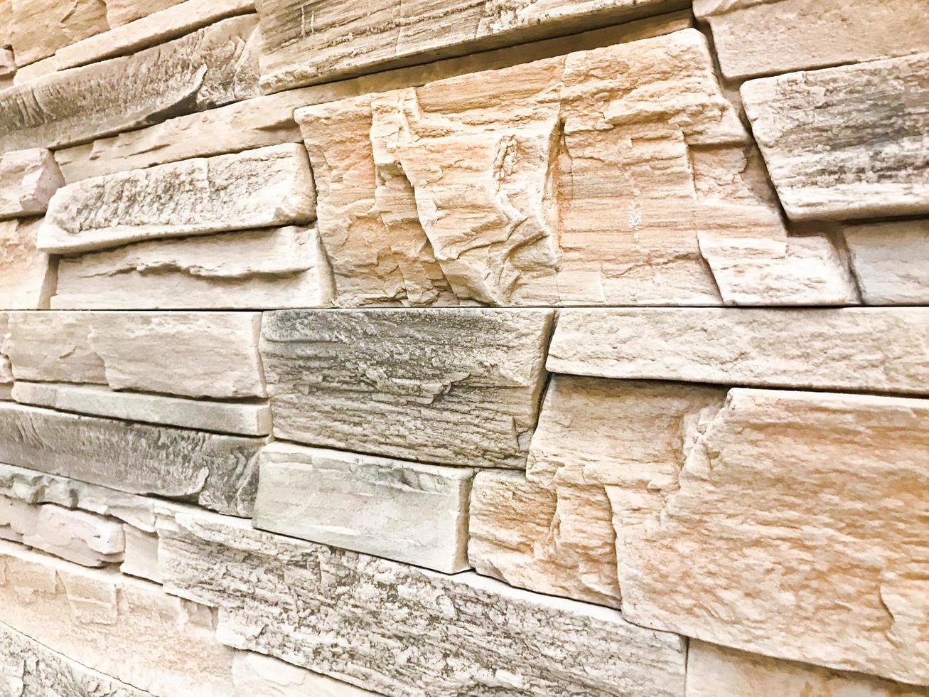 Beautiful texture of a decorative stone wall at an angle of construction gray textured relief stone with plaster with seams. The background photo