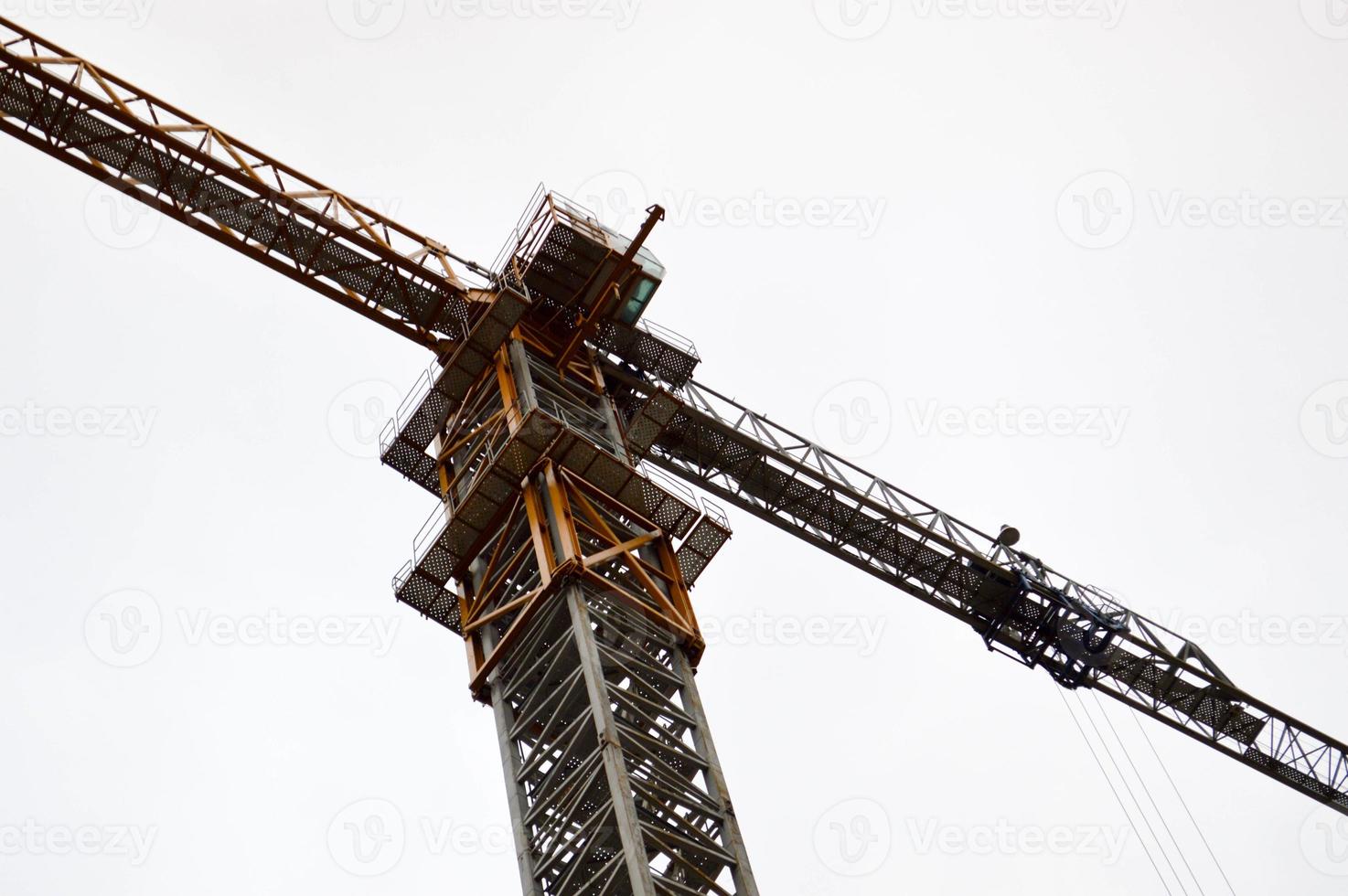 gran grúa industrial de carga de construcción poderosa en un sitio de construcción de nuevos edificios y casas contra el cielo foto