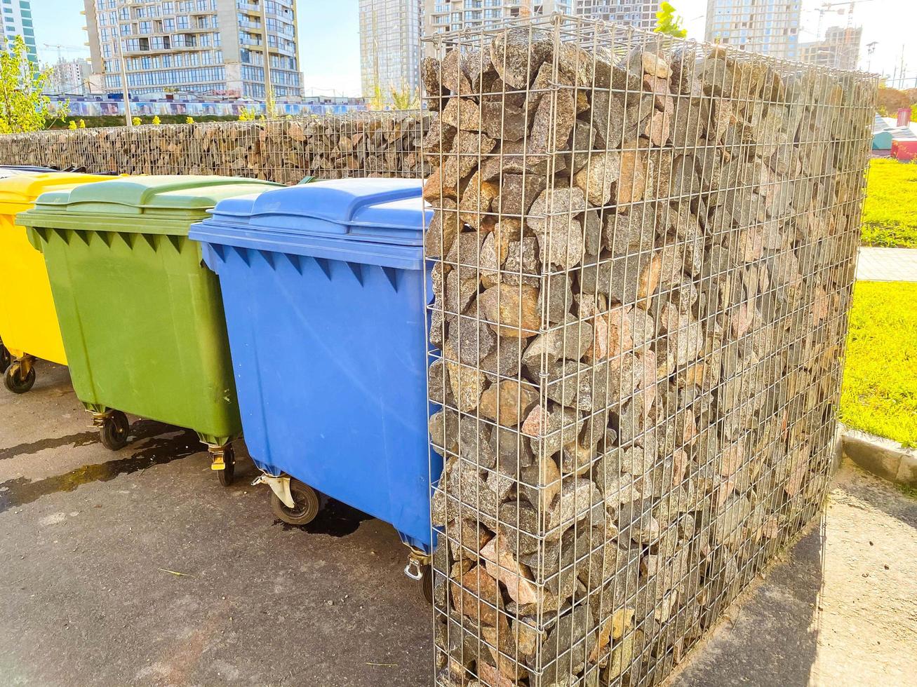 trash cans in the backyard. separate collection of garbage in multi-colored containers. environmental care, waste sorting photo
