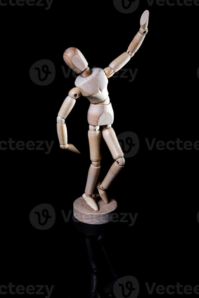 Image of wooden manikin on black background poses different posing photo