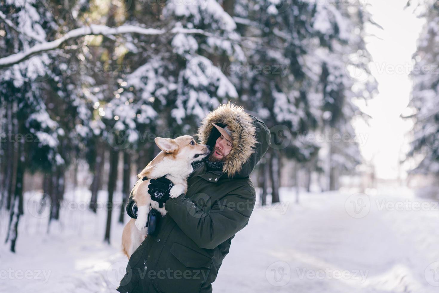 hombre alegre sostiene un perro corgi foto