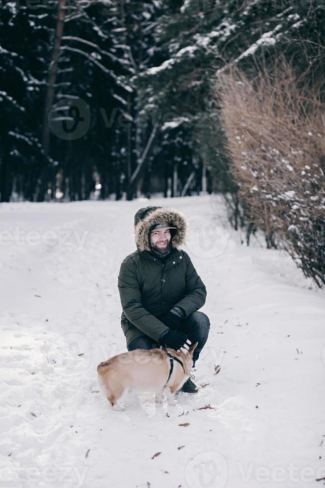 man in a jacket walks with a dog photo