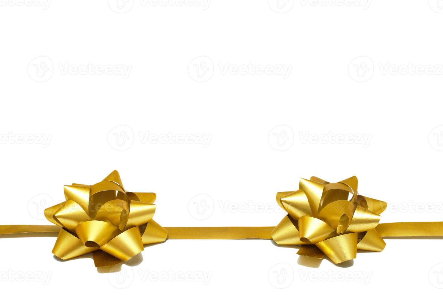 Two golden gift bows with a ribbon on a white background with copy space. isolated object. Universal template for postcards, posters, banners photo