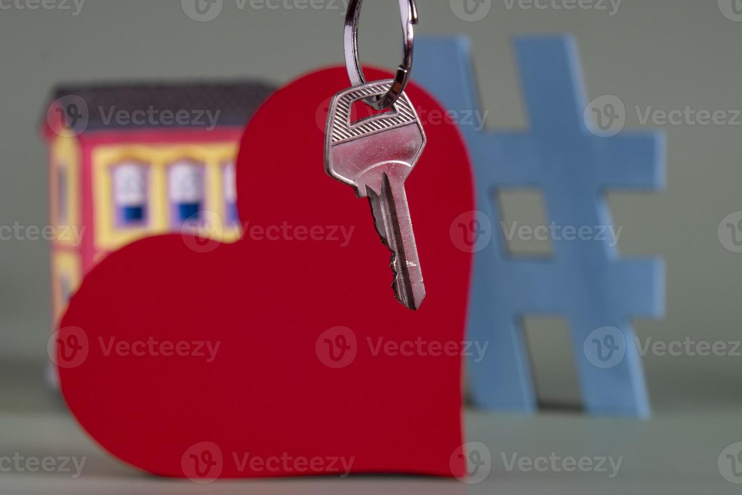 House symbol with metal key and property miniature, symbolizing home ownership photo