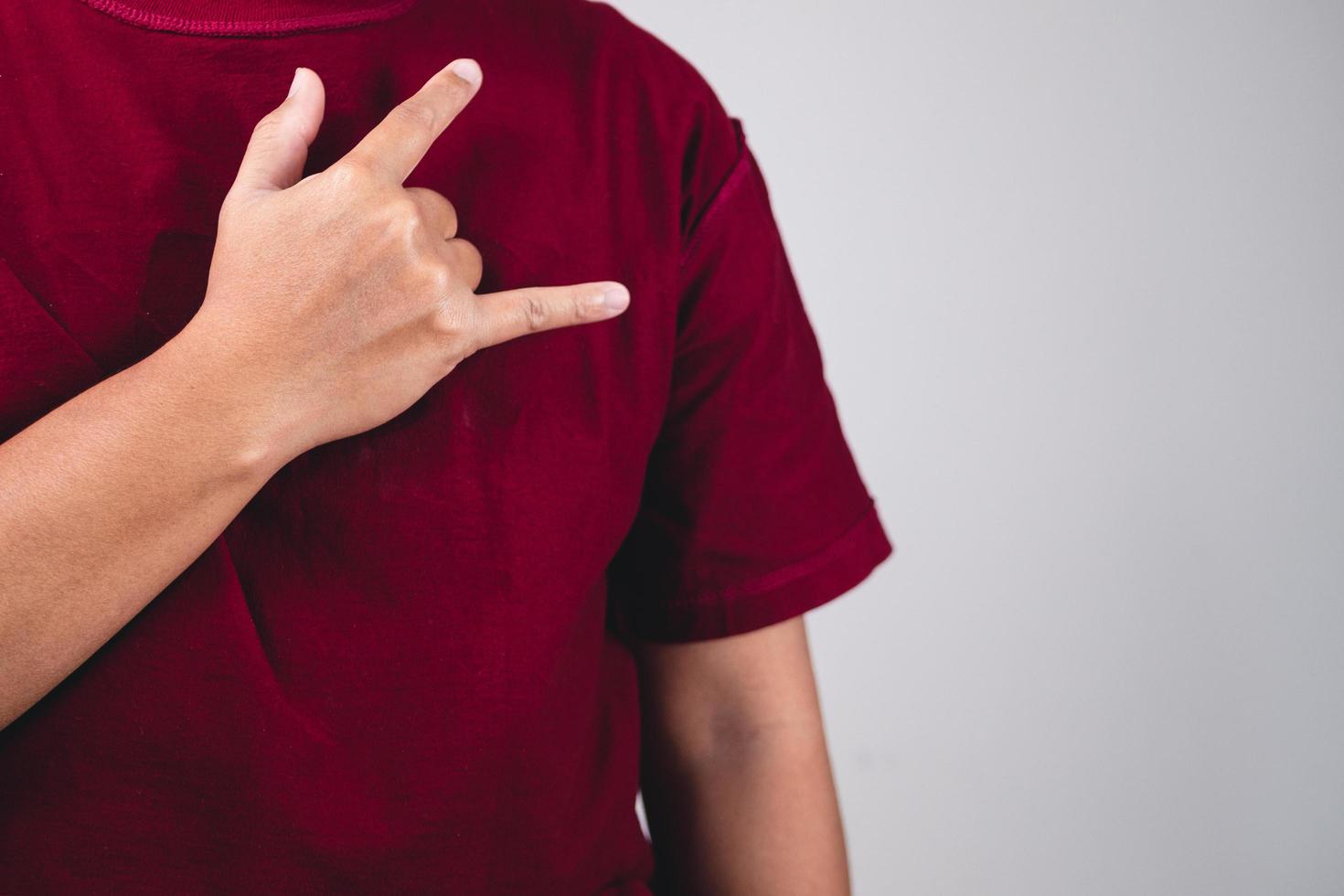 signo de amor propio. abrazarte a ti mismo y pensar en positivo. el hombre con camisa roja en primer plano medio. copiar espacio para mensajes, palabras y textos. foto