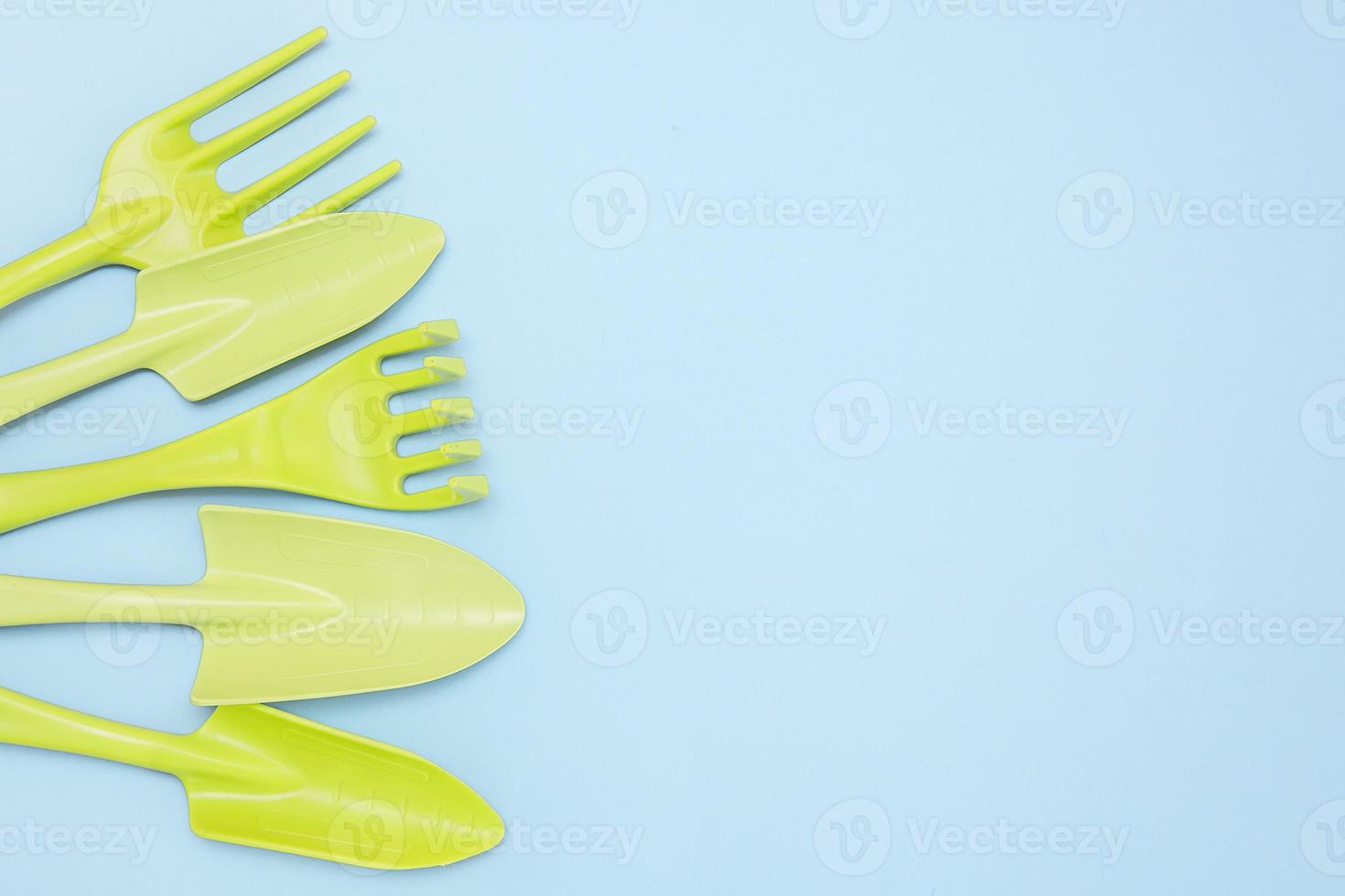 tools for gardening and floriculture, rakes, shovels on a blue background with copy space photo