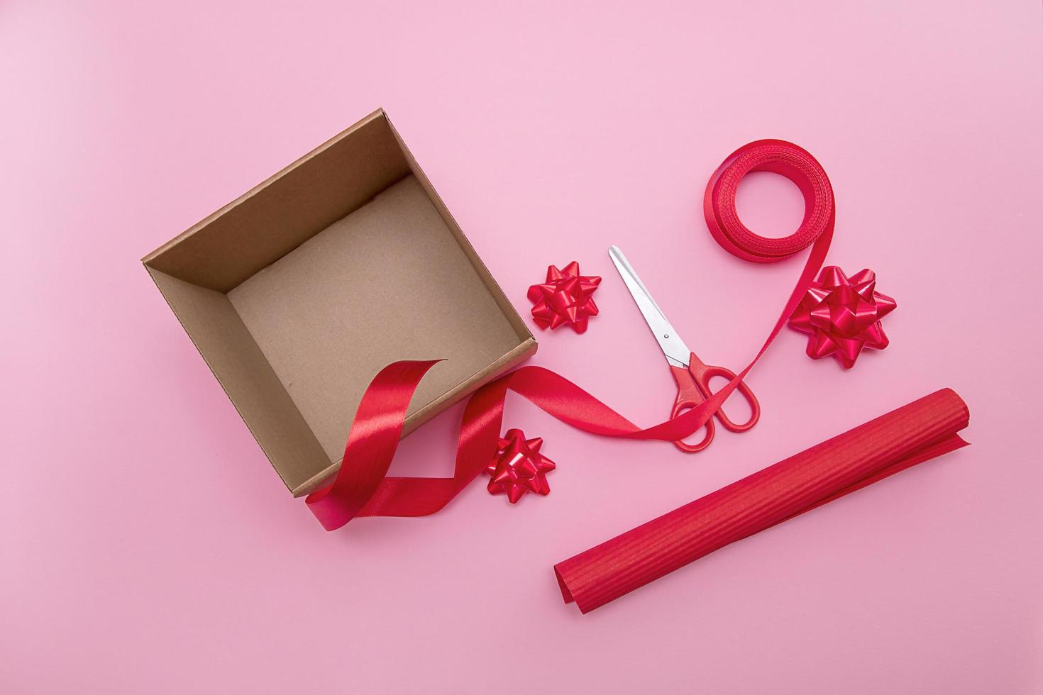 caja de regalo abierta, tijeras, cinta, papel de regalo, lazos para decorarlo foto