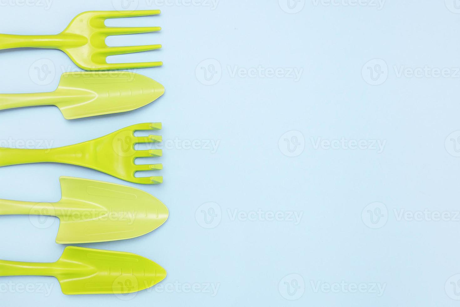 tools for gardening and floriculture, rakes, shovels on a blue background with copy space photo