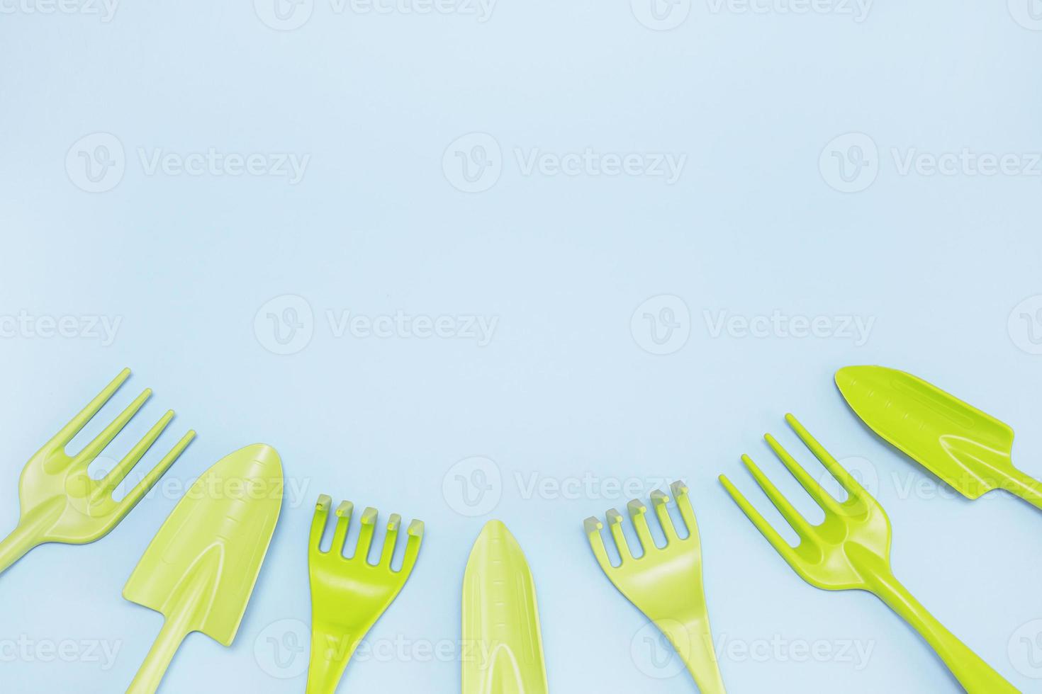 tools for gardening and floriculture rake spades on a blue background laid out from below in a semicircle with copy space photo