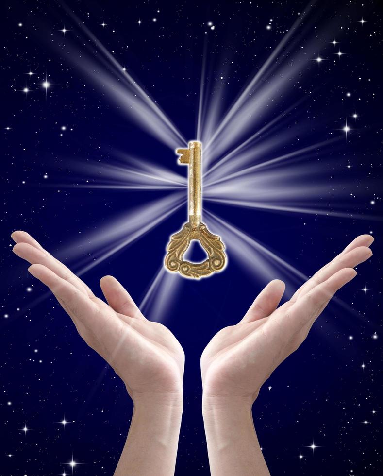 the key to success, hand holding key against night sky photo
