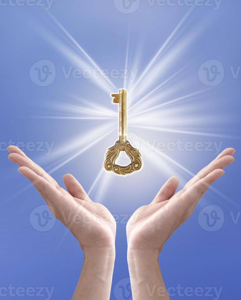 the key to success, hand holding key against blue sky photo