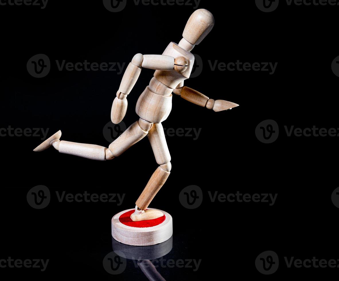Image of wooden manikin on black background poses different posing photo