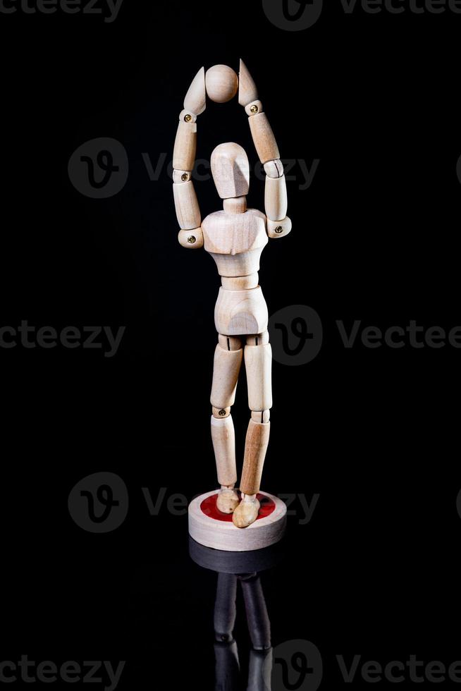 Image of wooden manikin on black background poses different posing photo