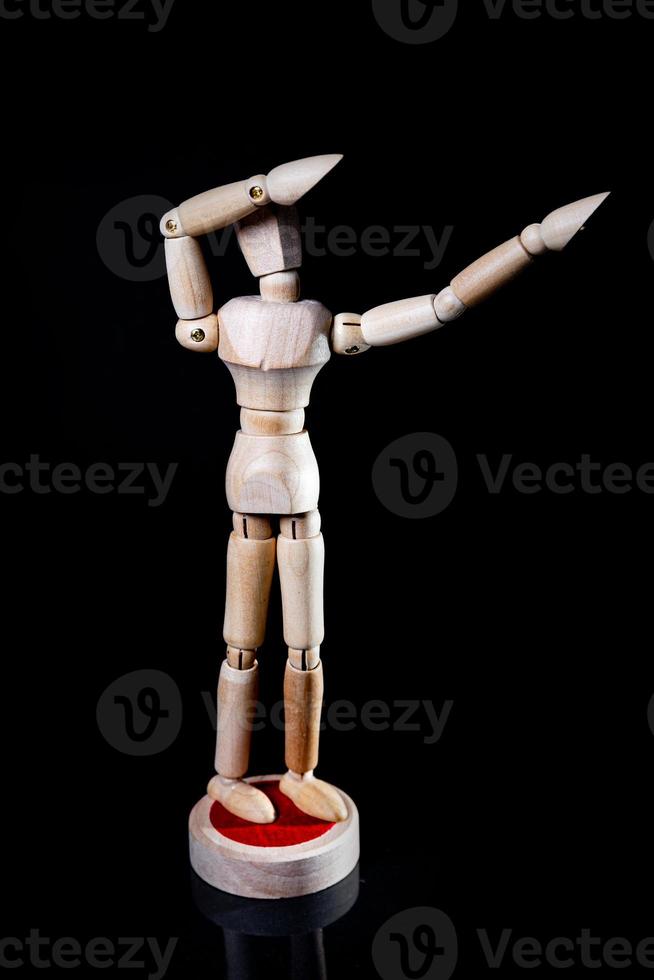 Image of wooden manikin on black background poses different posing photo