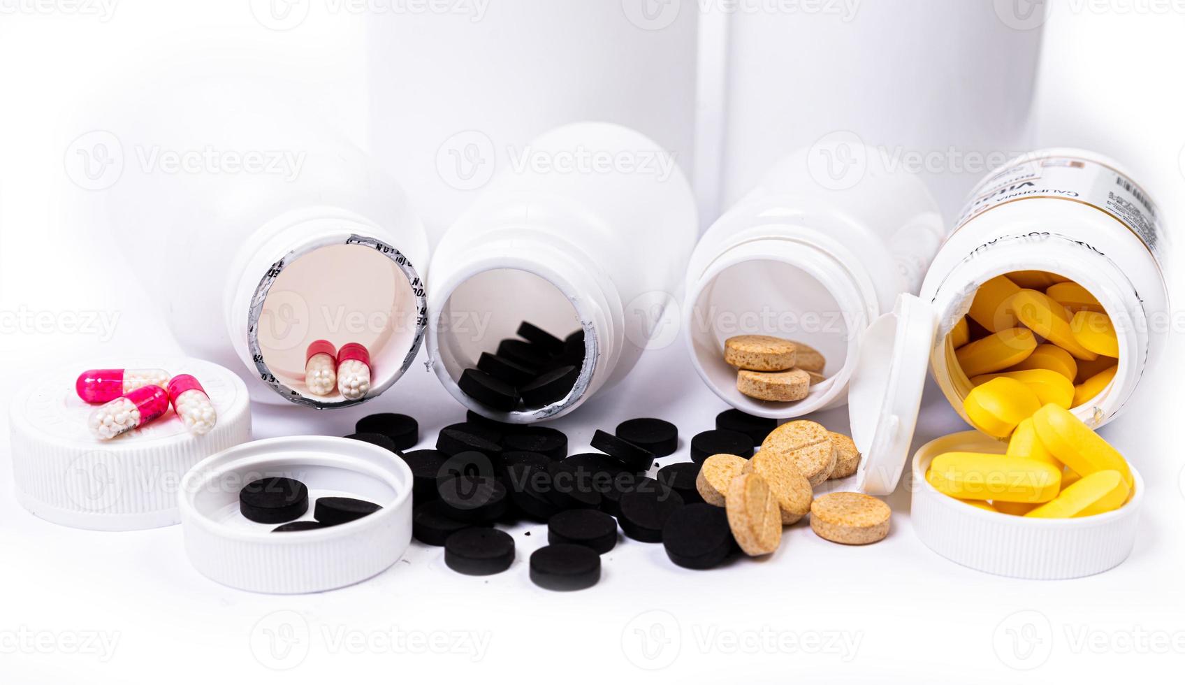 Medical pills spill out of a white jar on an isolated on white background photo