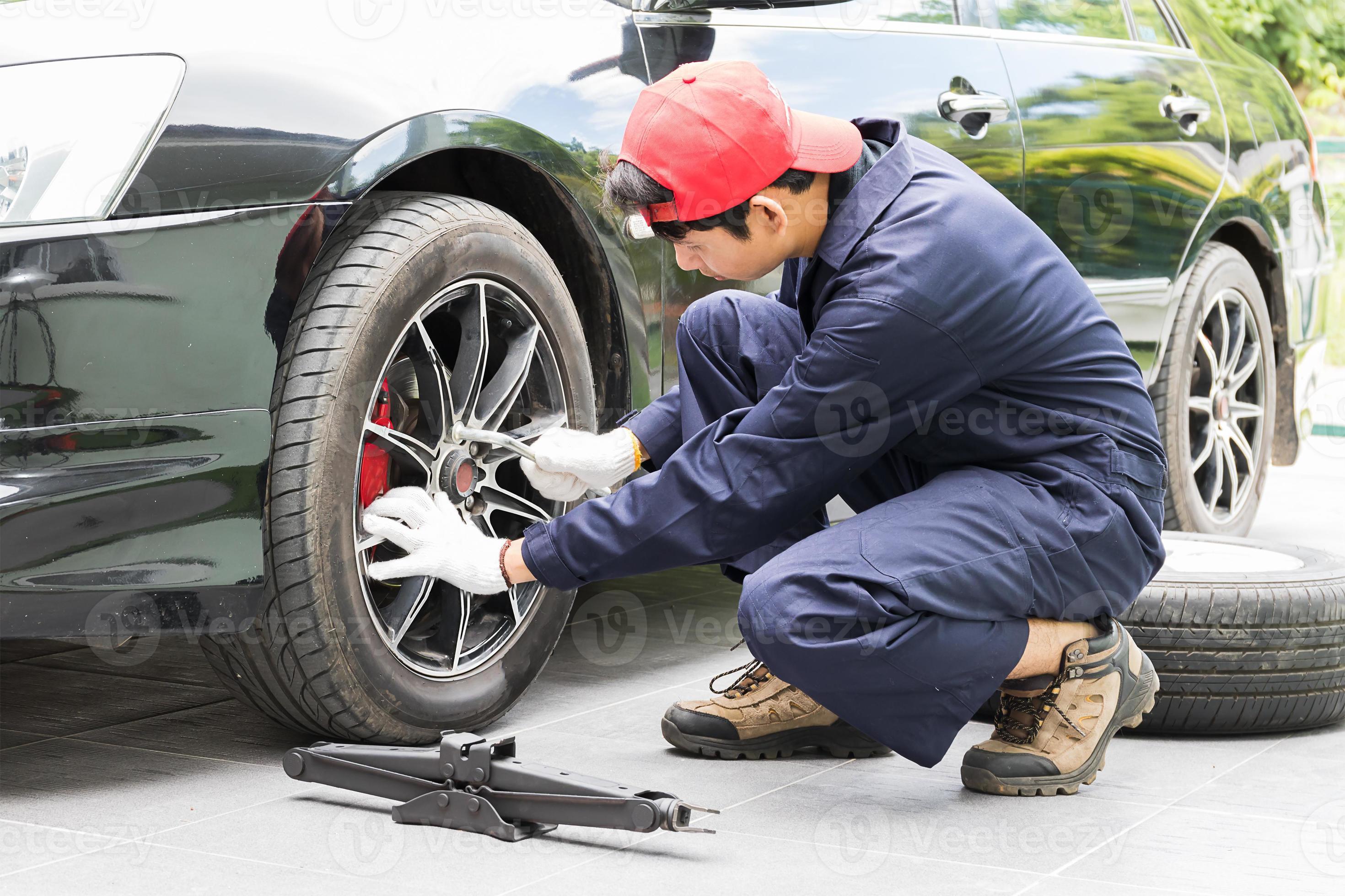 Mechanic replacing lug nuts changing tires on vehicle 13873244 Stock
