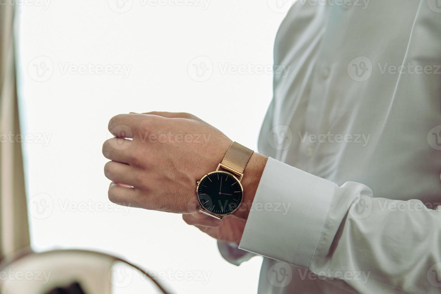 man putting clock on hand,groom getting ready in the morning photo