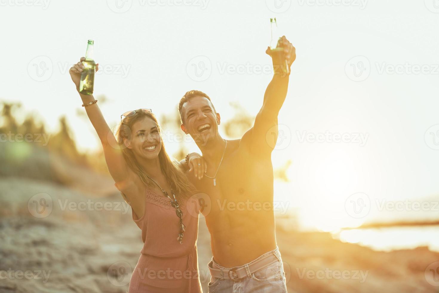 pareja disfrutando del atardecer en la playa foto