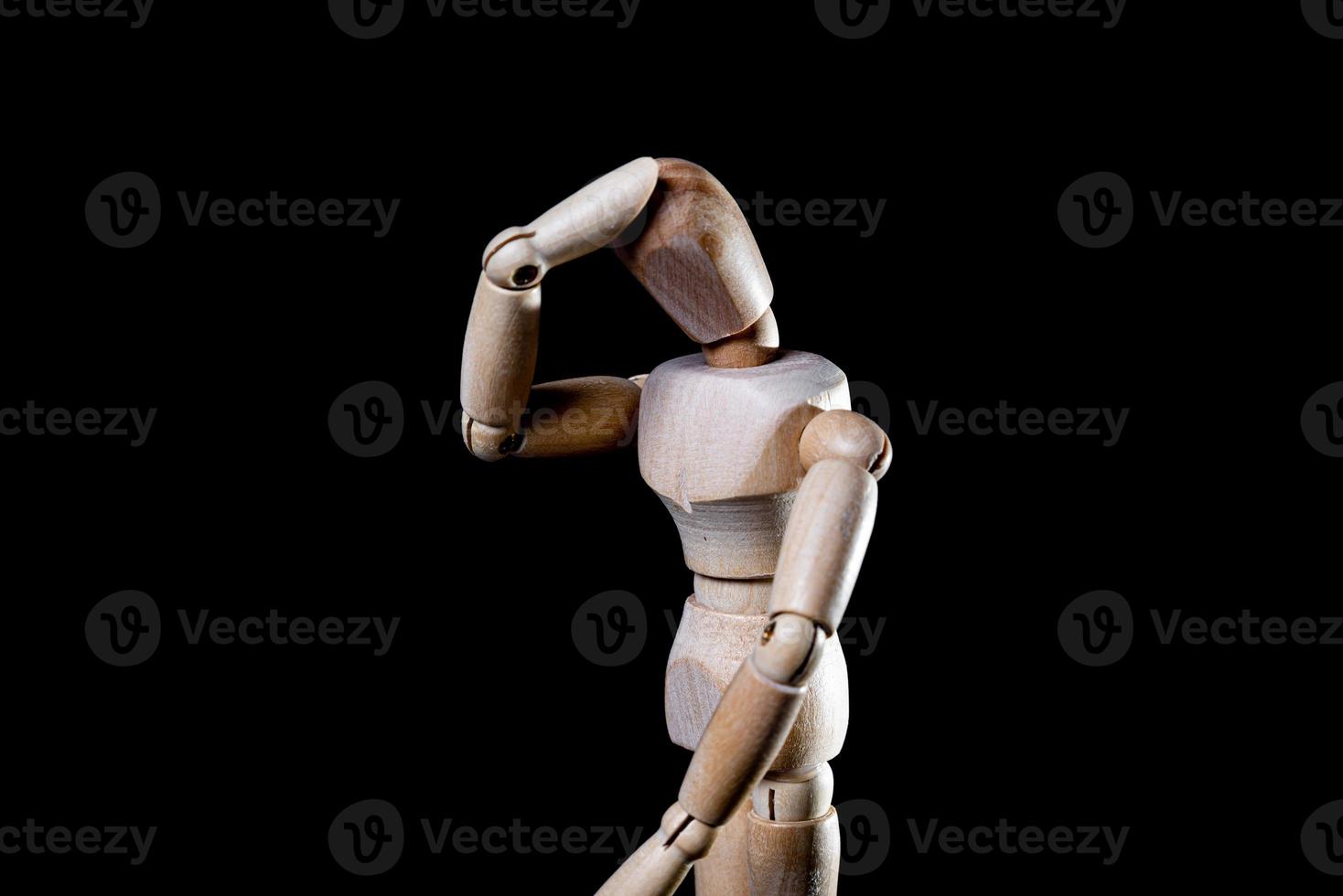 Image of wooden manikin on black background poses different posing photo