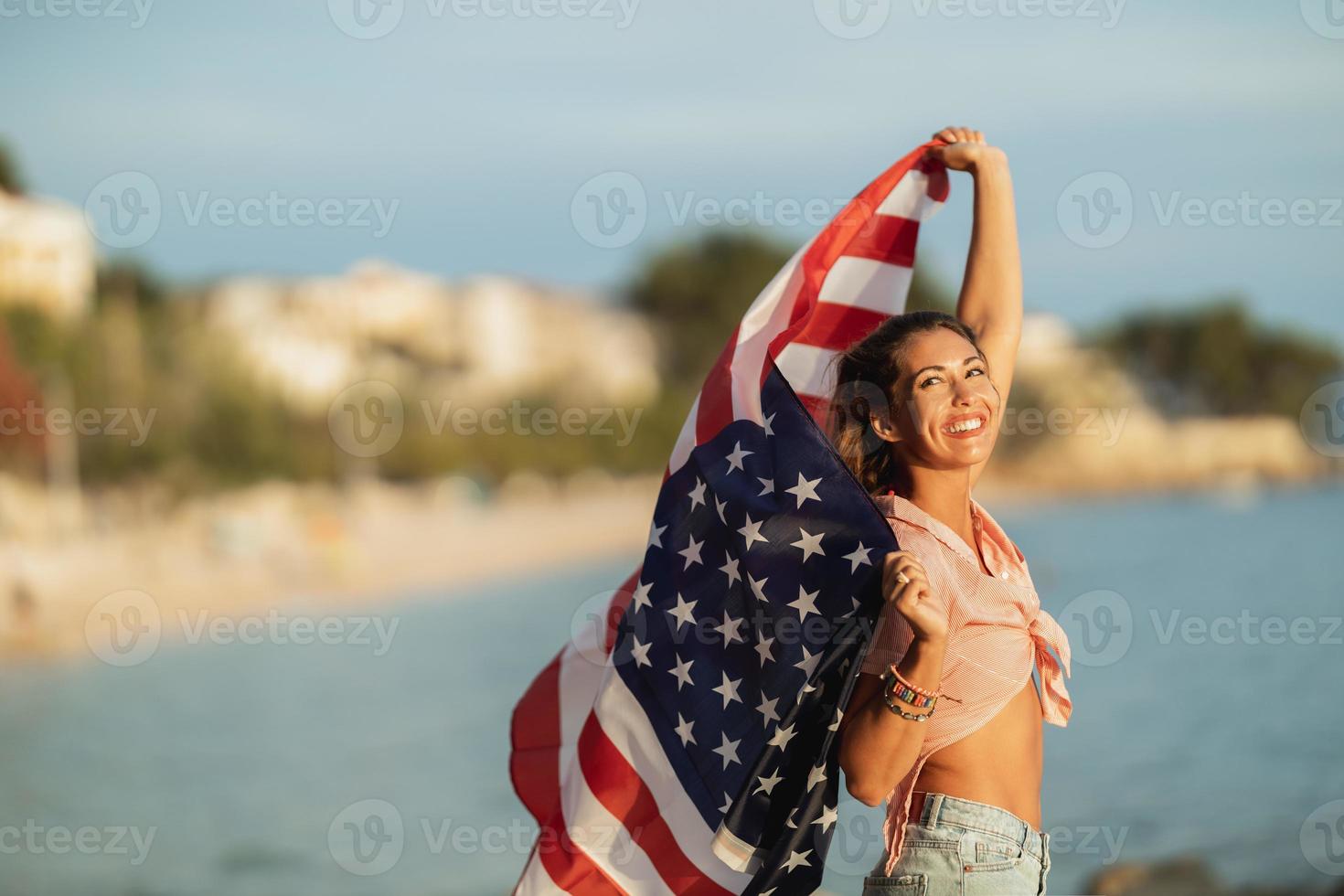 Woman With American National Flag Spending Day On A Beach photo