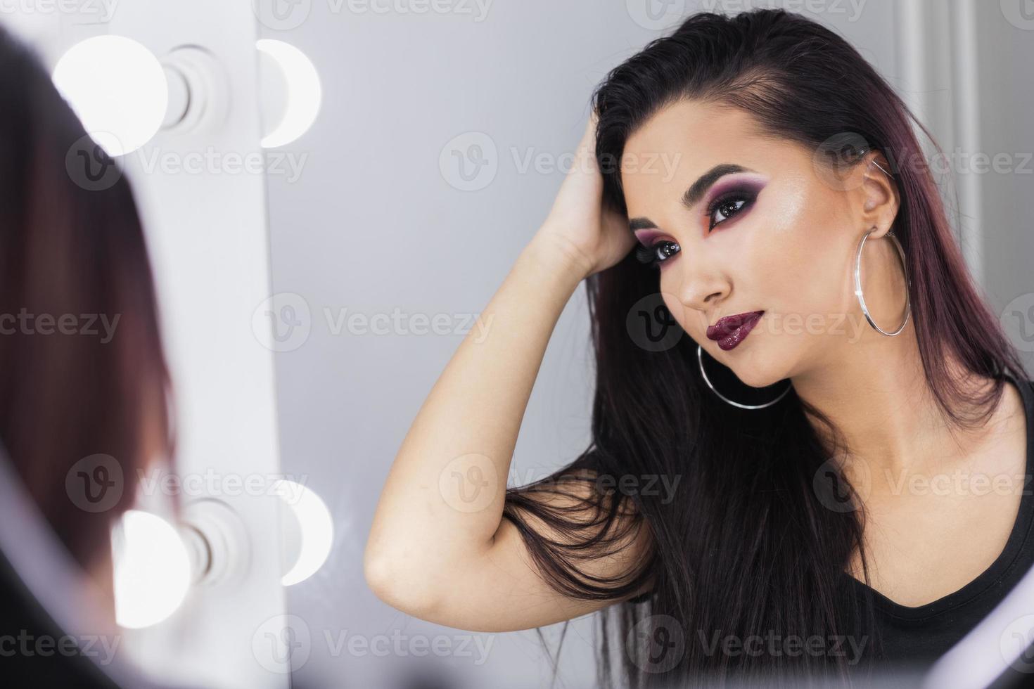 Woman Styling Her Hair In Front Of Mirror photo