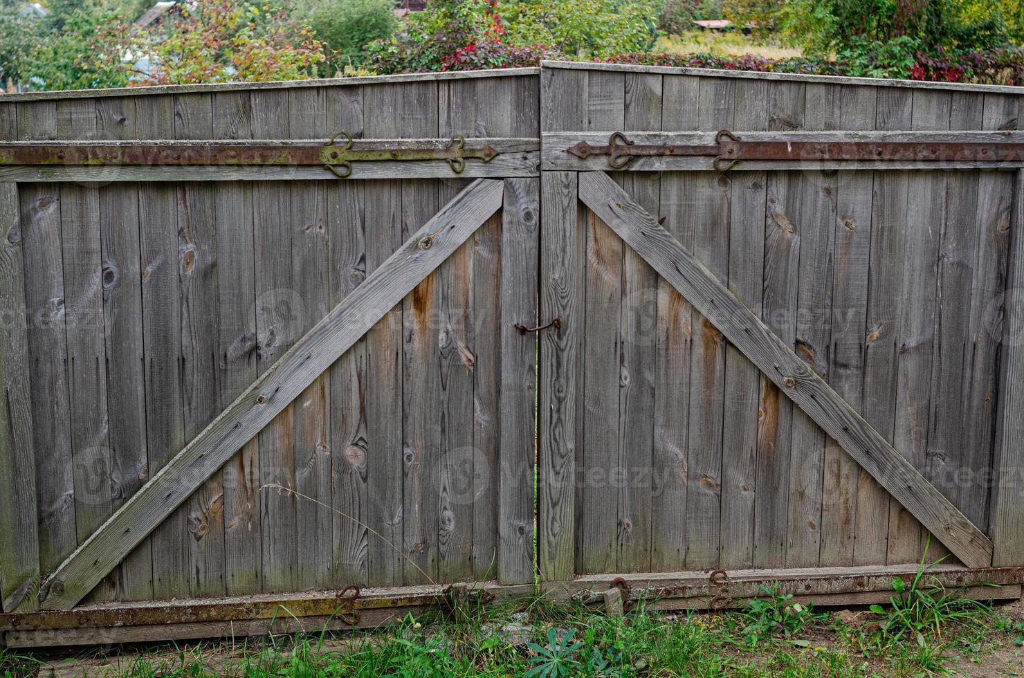 old weathered door in the wooden wall of an ancient hut photo