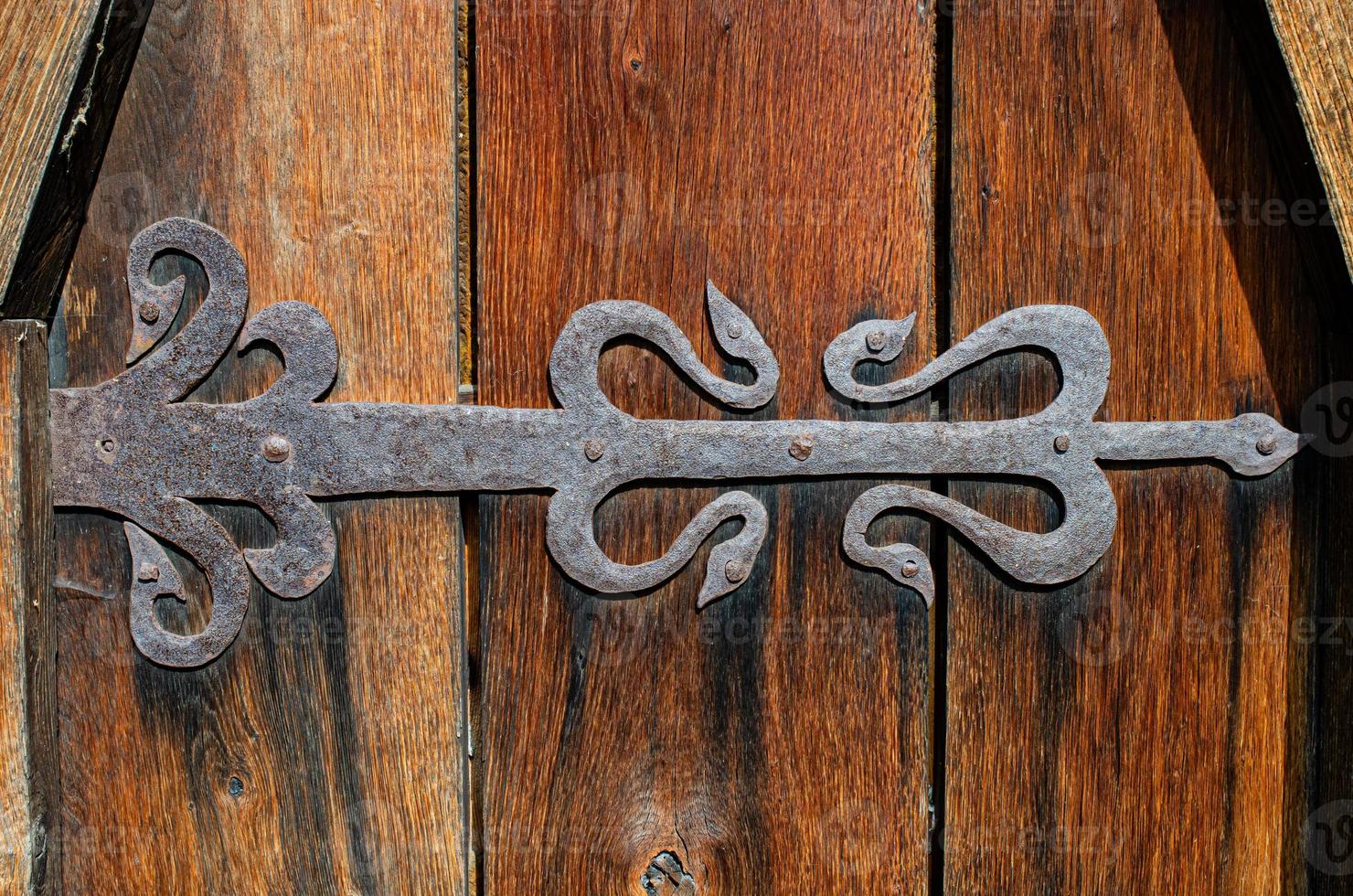 Old wooden gate closed on rusty padlock, texture photo