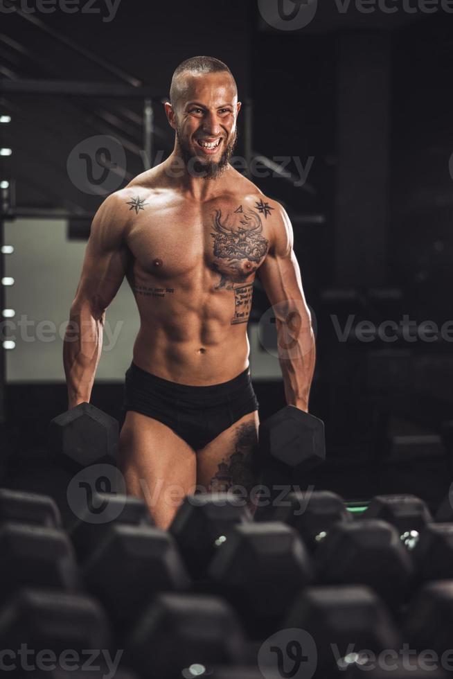 Man Doing Training With Dumbbell For His Arms Muscle At The Gym photo