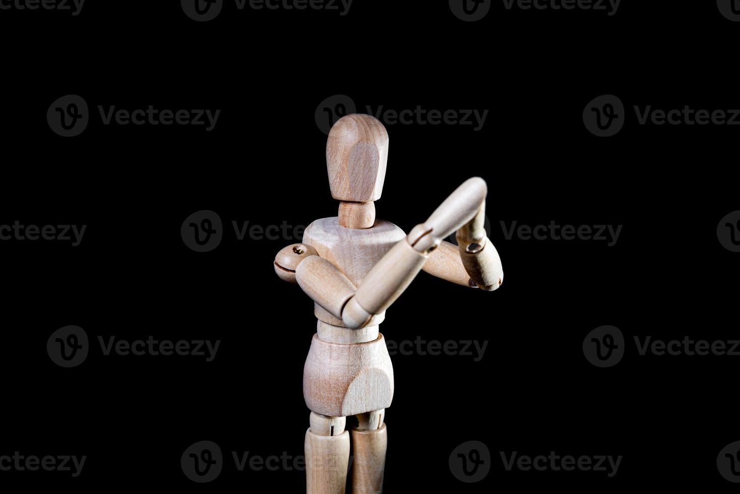 Image of wooden manikin on black background poses different posing photo