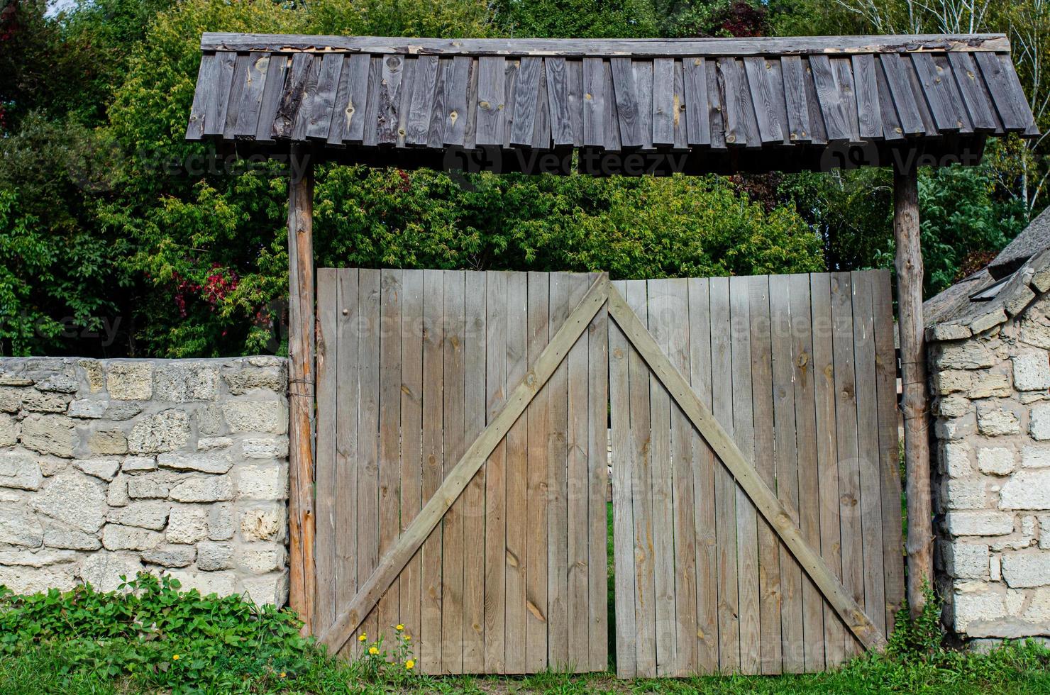 old weathered door in the wooden wall of an ancient hut photo