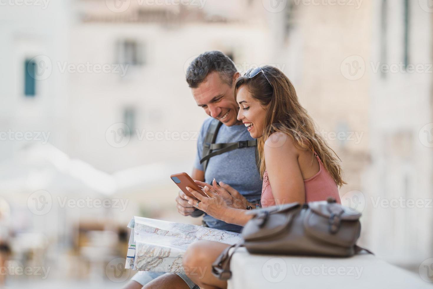Tourist Couple On A Summer Vacation Discovering The Mediterranean City Map And Guidebook photo